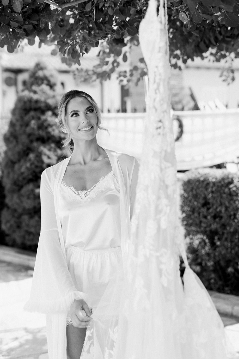 Black and white bridal portrait featuring elegant white dress and natural garden setting.