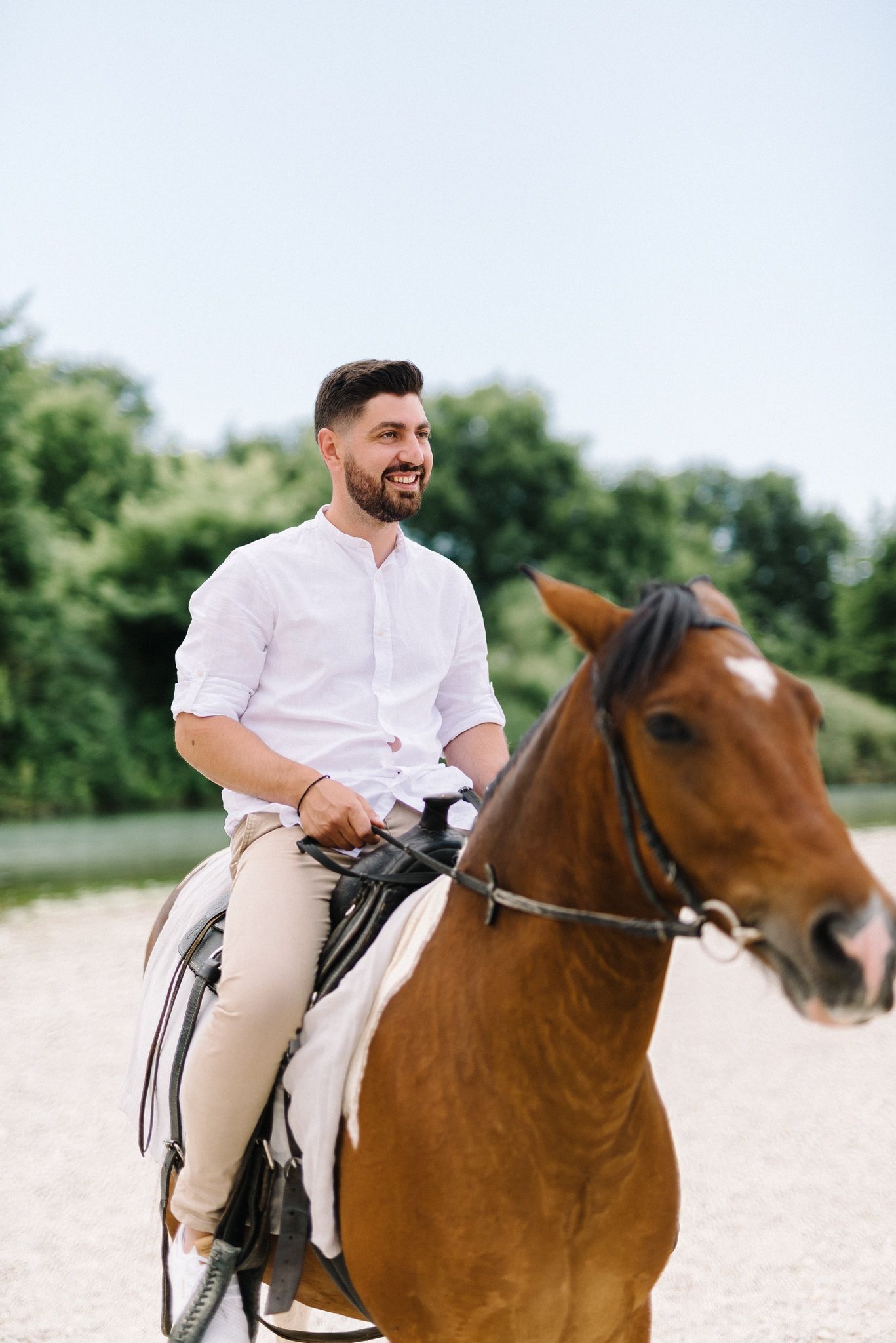 groom portrait riding horse in acheron river in greece