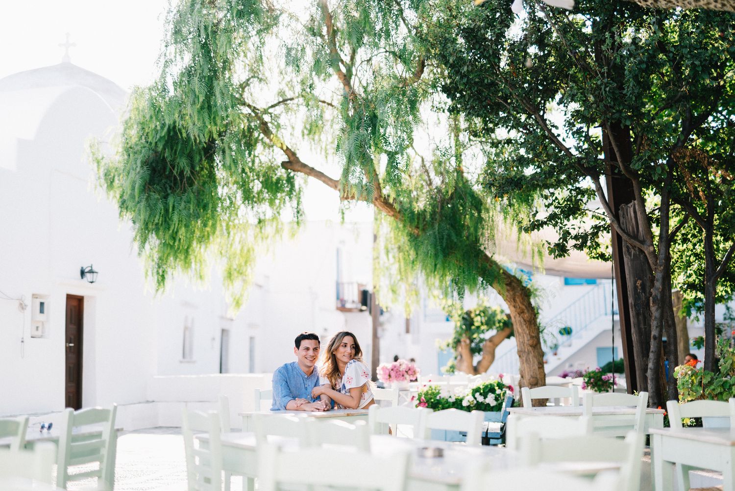 couple sitting in a beautiful square at folegandros island in Greece