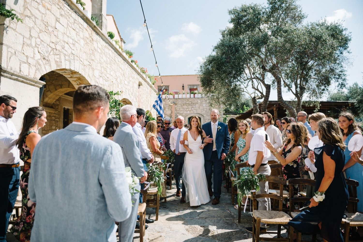 Wedding ceremony under string lights at a Mediterranean stone venue.