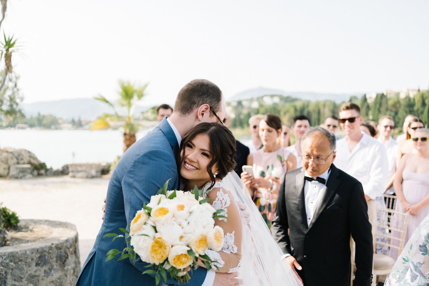 Wedding ceremony moment with yellow bouquet and guests in attendance.