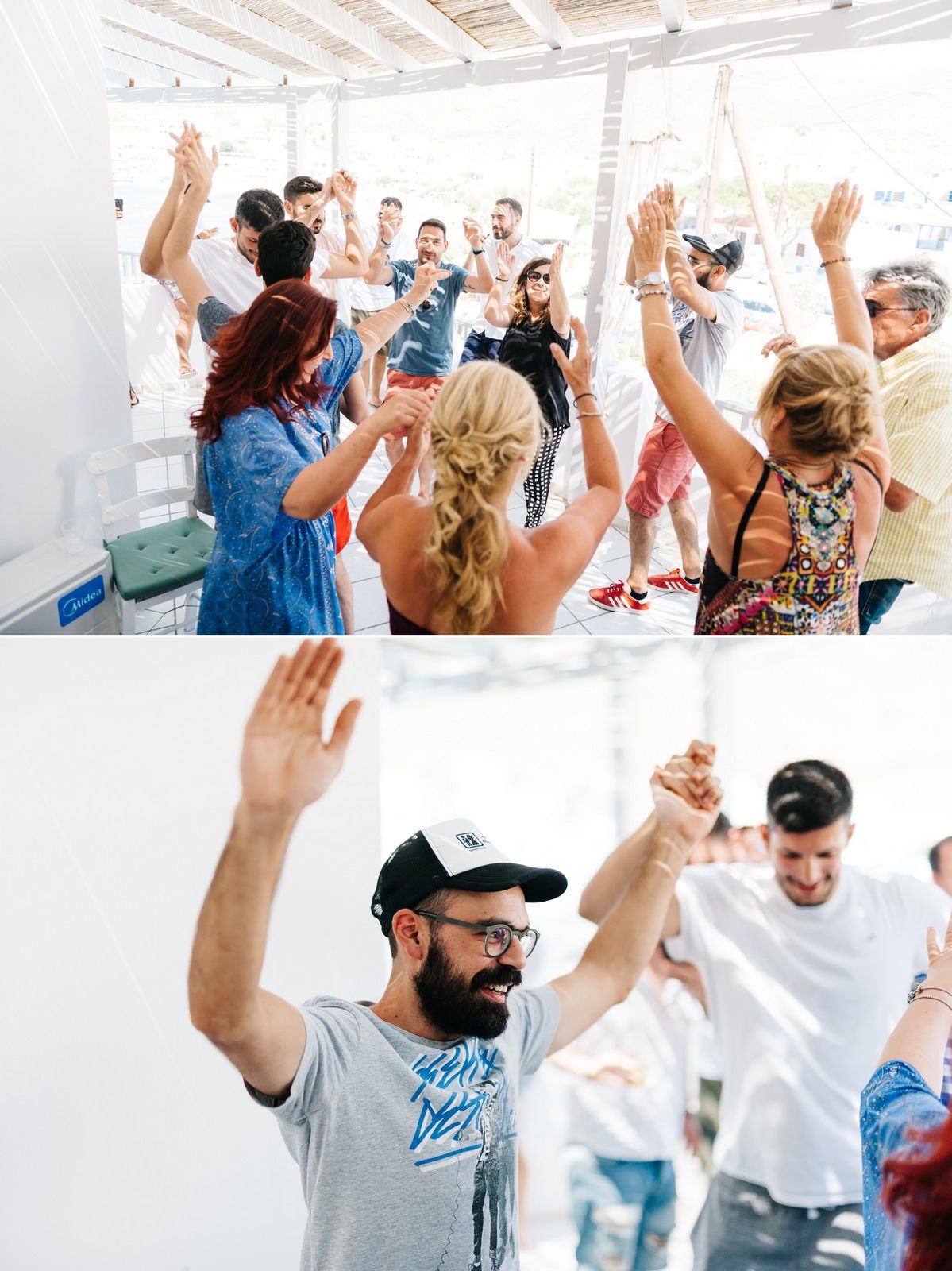 Energetic group of party guests dancing with raised hands in white Mediterranean venue.