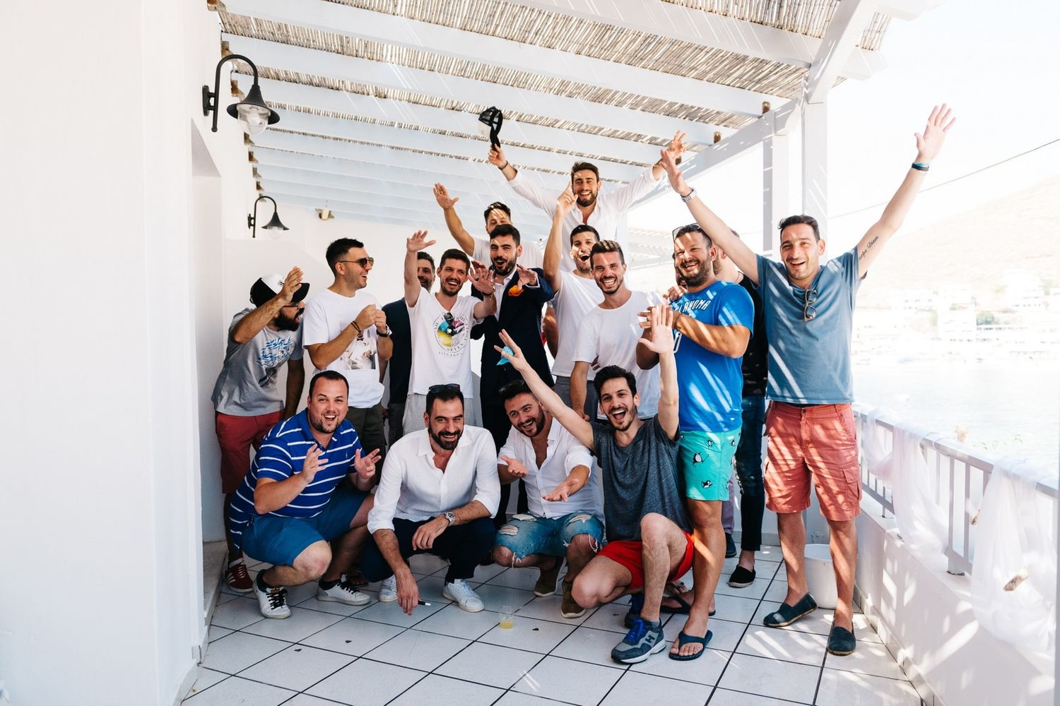 Group photo of friends posing together in a bright indoor space with white walls.