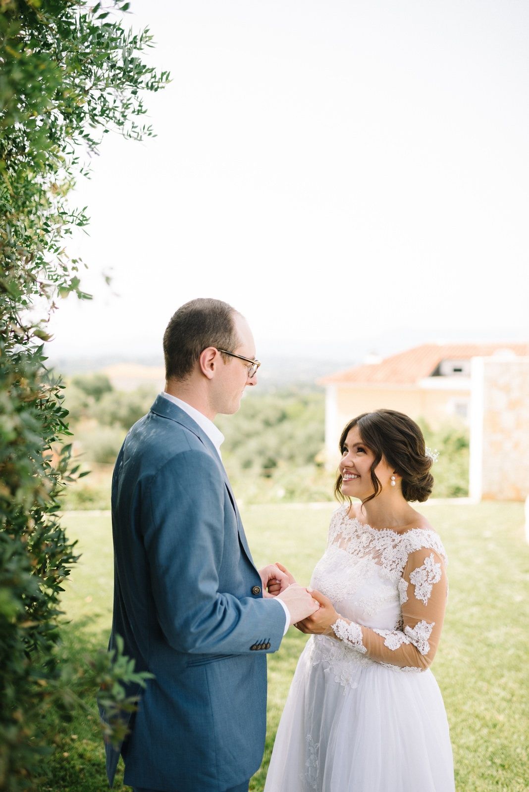 Intimate outdoor wedding moment with couple standing amidst greenery.