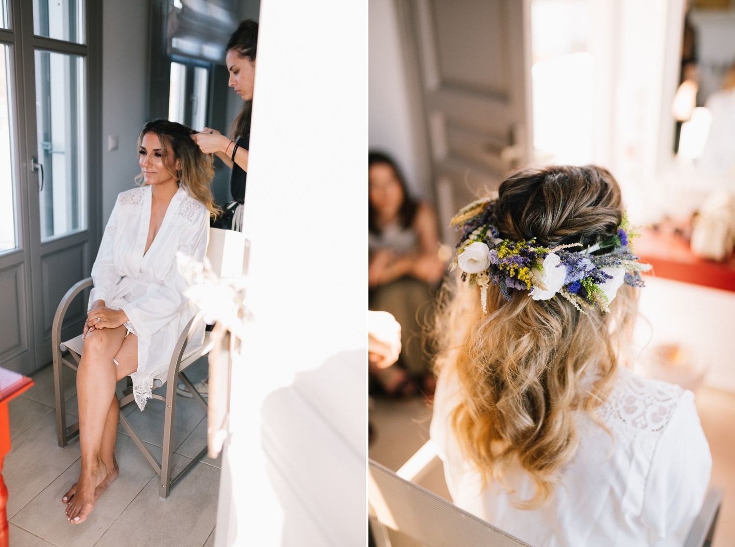 Bride getting hair and makeup done in white robe while preparing for wedding day festivities.