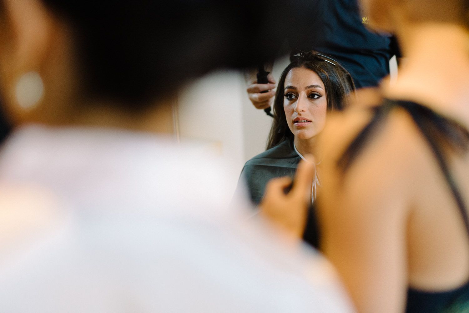 Wedding preparation scene with focus on styling in mirror reflection.