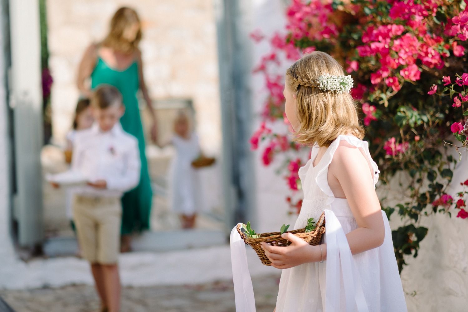 Mediterranean wedding scene with bright bougainvillea flowers and traditional whitewashed architecture.