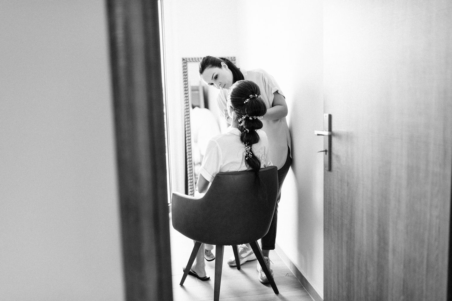 Black and white photo of wedding preparations reflected in mirror.