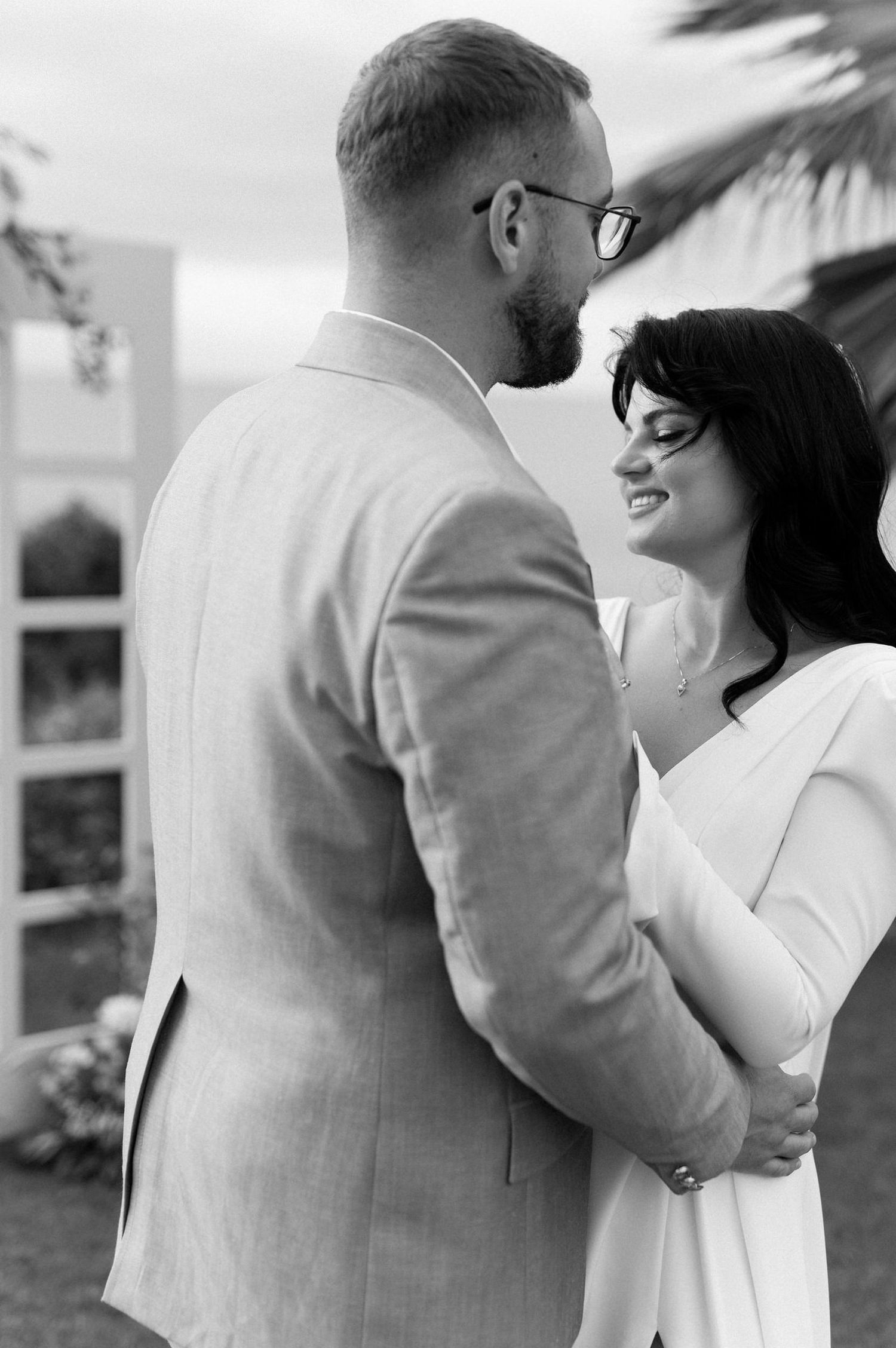 Black and white wedding photos capturing intimate moments between a couple in formal attire.