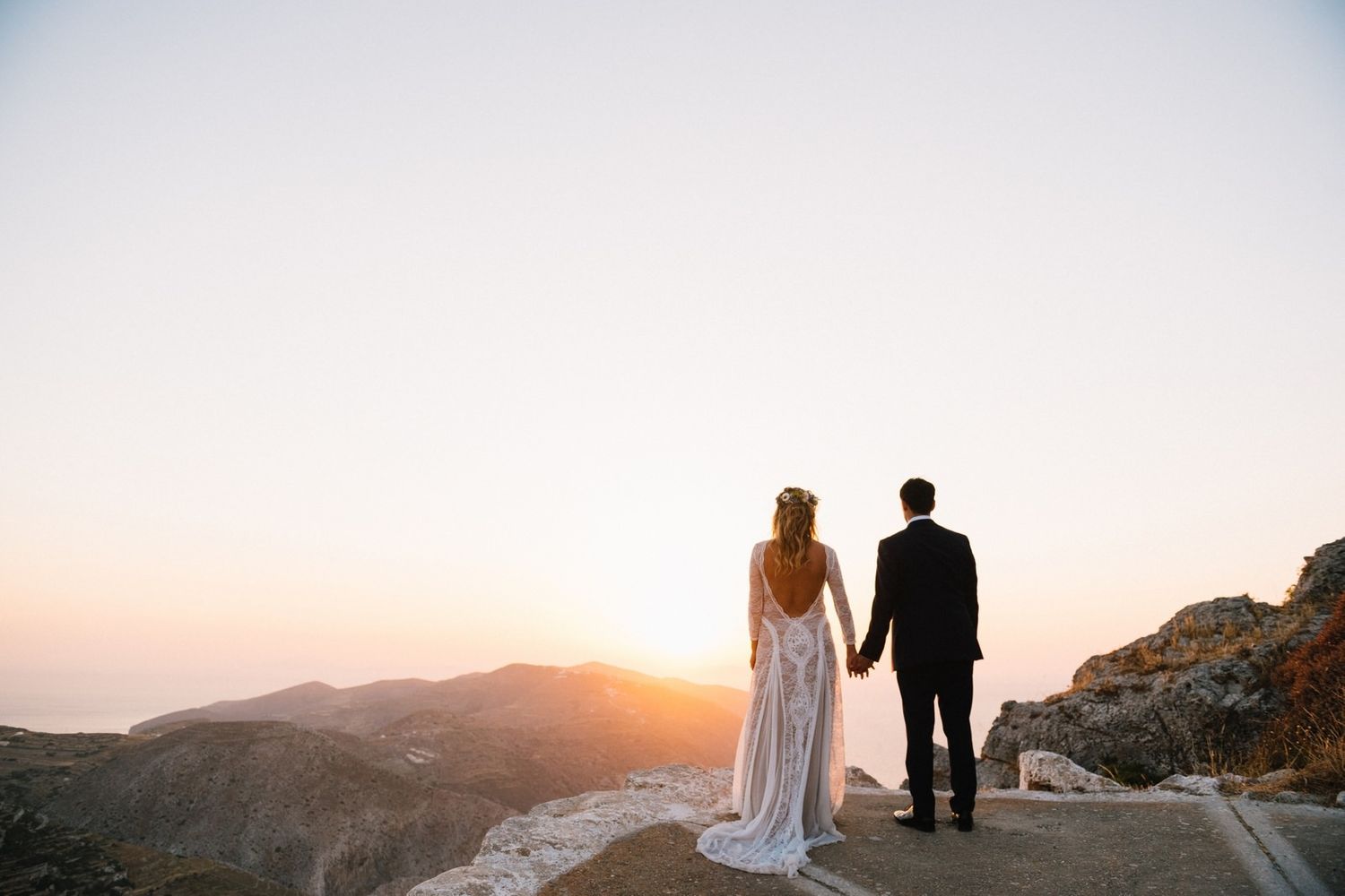 bride and groom watching the sunset at folegandros