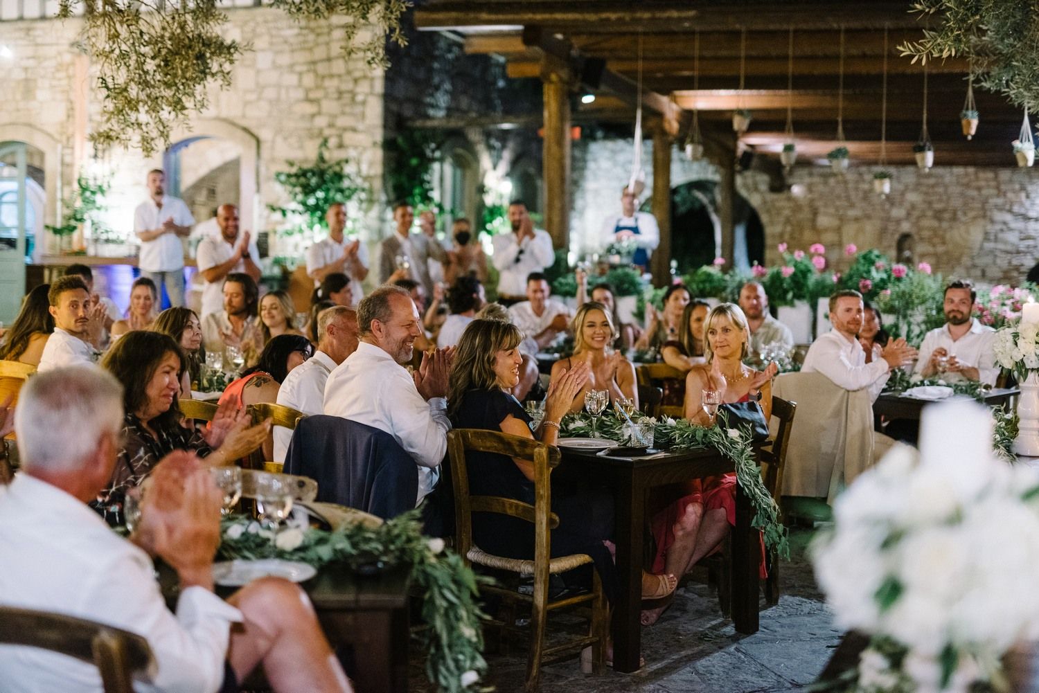 Elegant indoor reception venue filled with wedding guests at decorated dining tables.