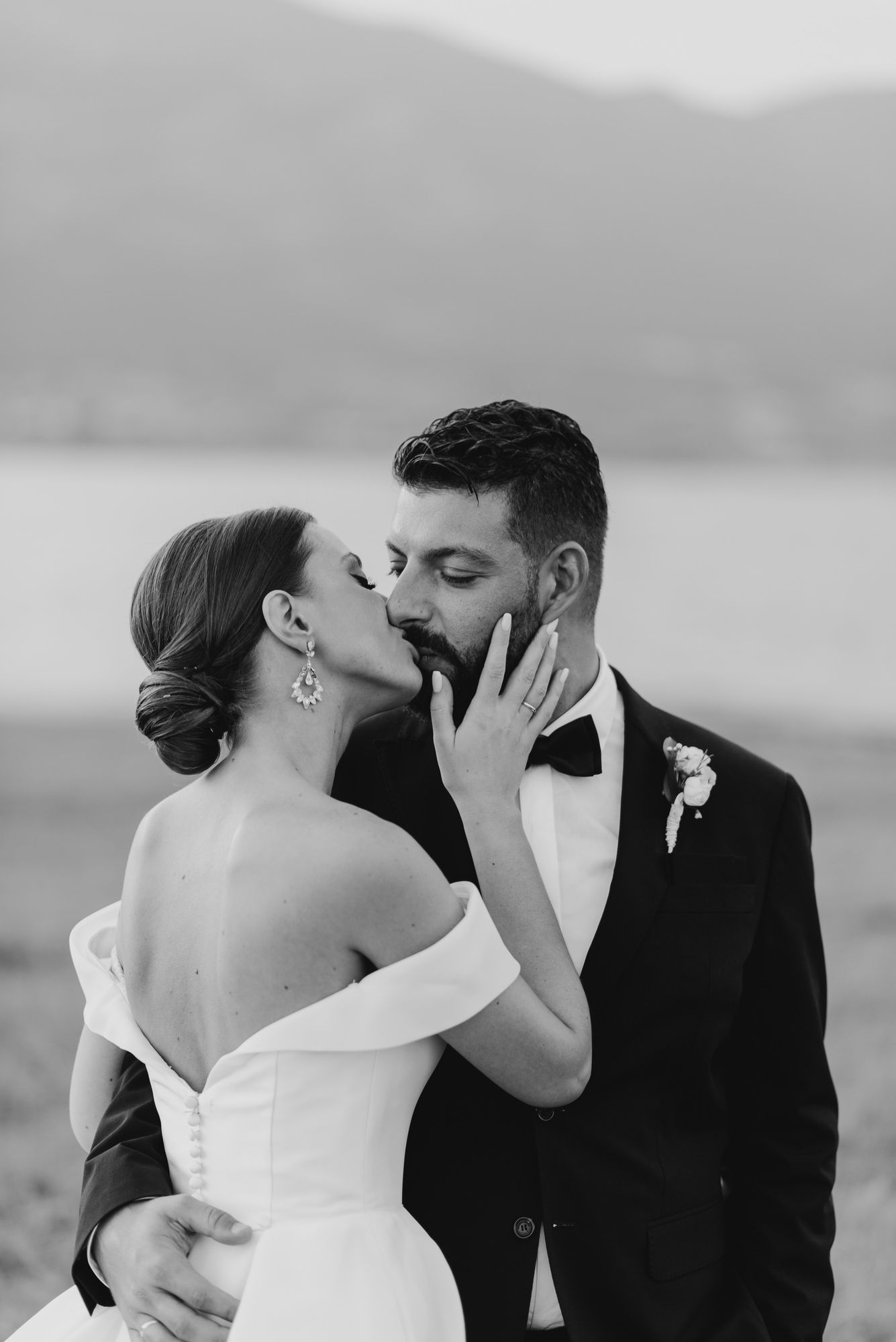 A romantic black and white wedding photo series showing tender moments between newlyweds sharing intimate kisses.