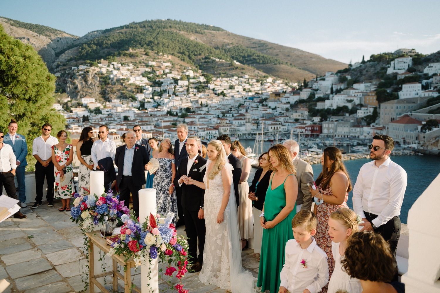 Destination wedding celebration on a terrace overlooking a coastal Mediterranean village.