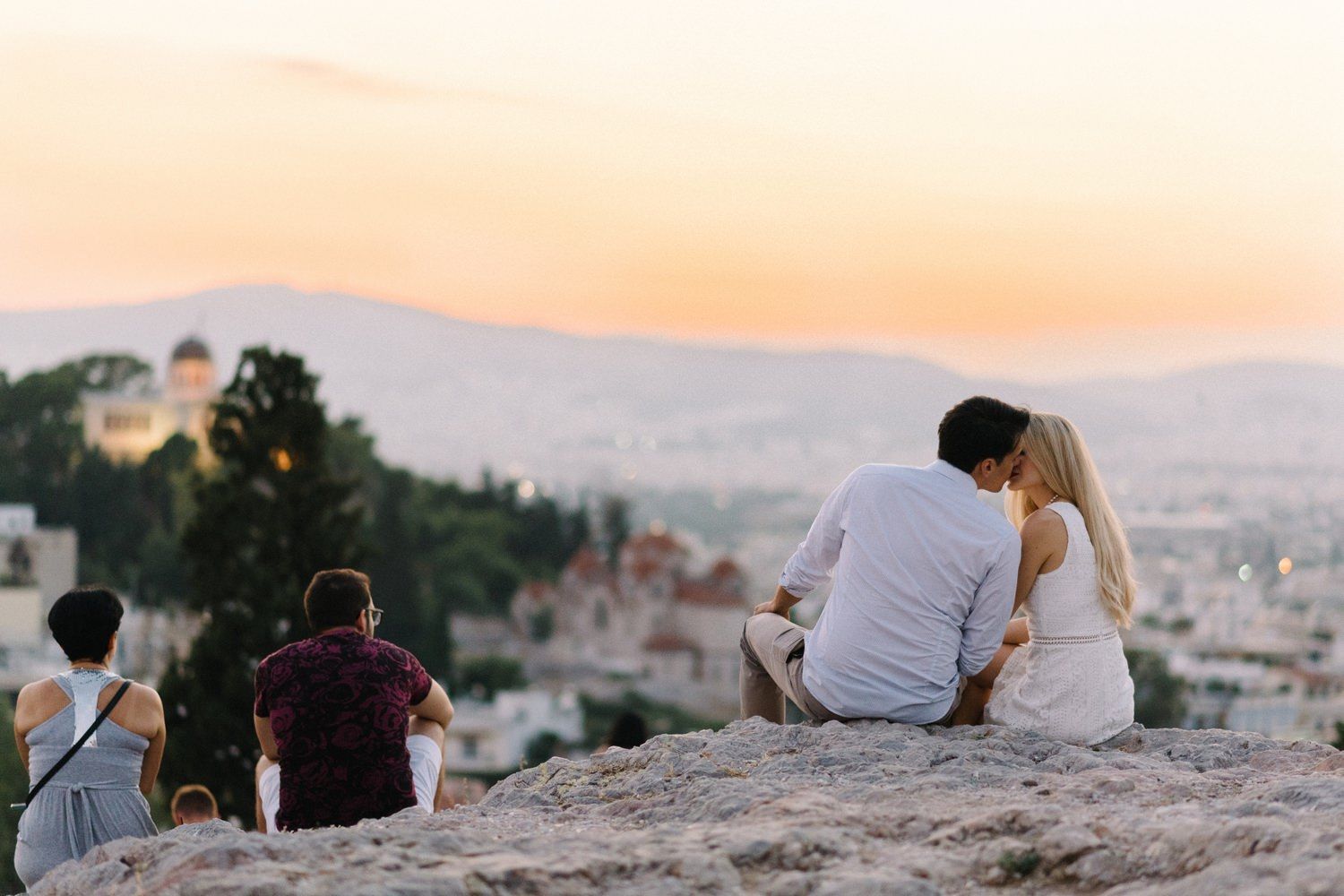 couple hug in filopappou hill athens with an amazing sunset