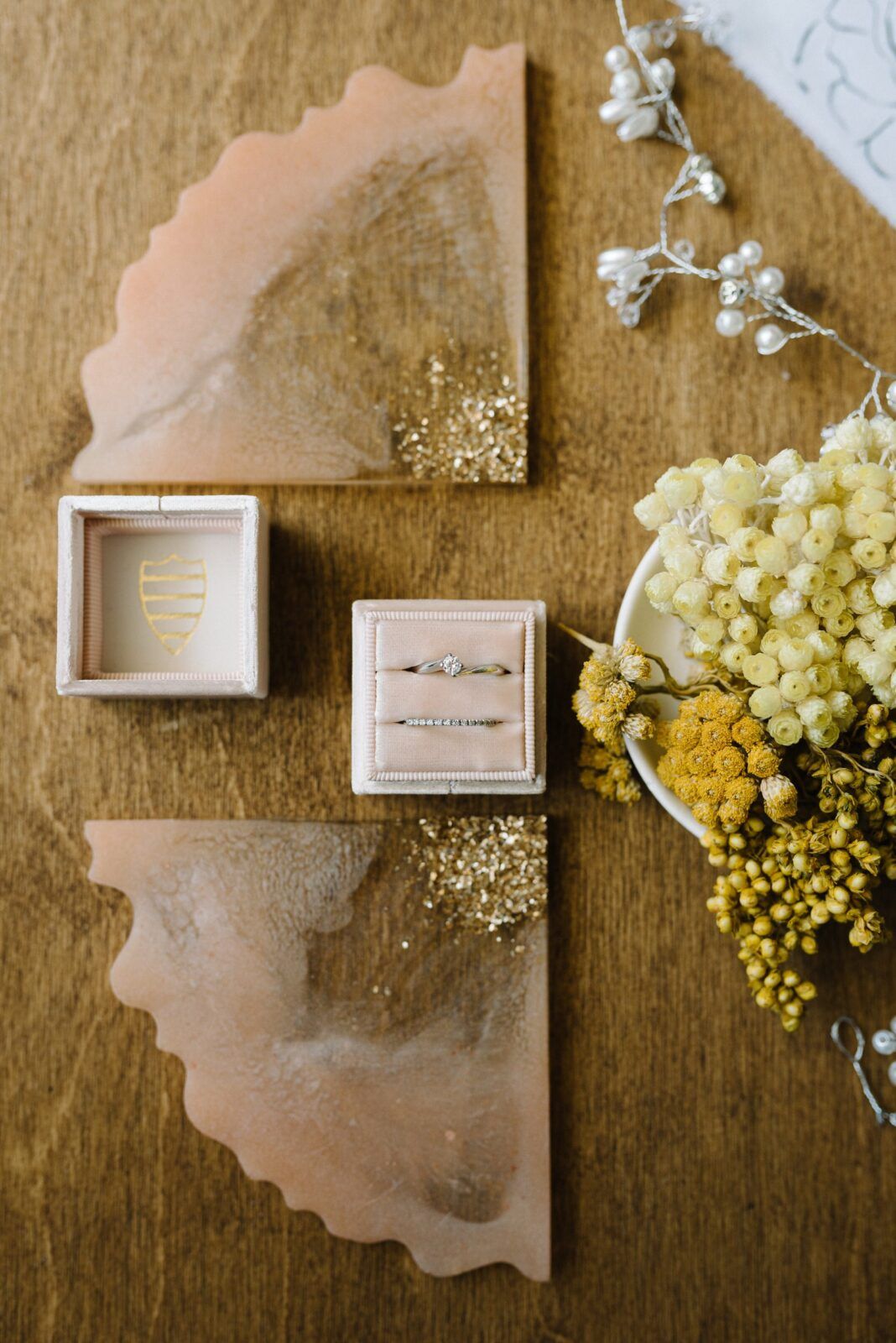 Delicate floral arrangement with yellow baby's breath flowers and paper elements displayed on a wooden surface.