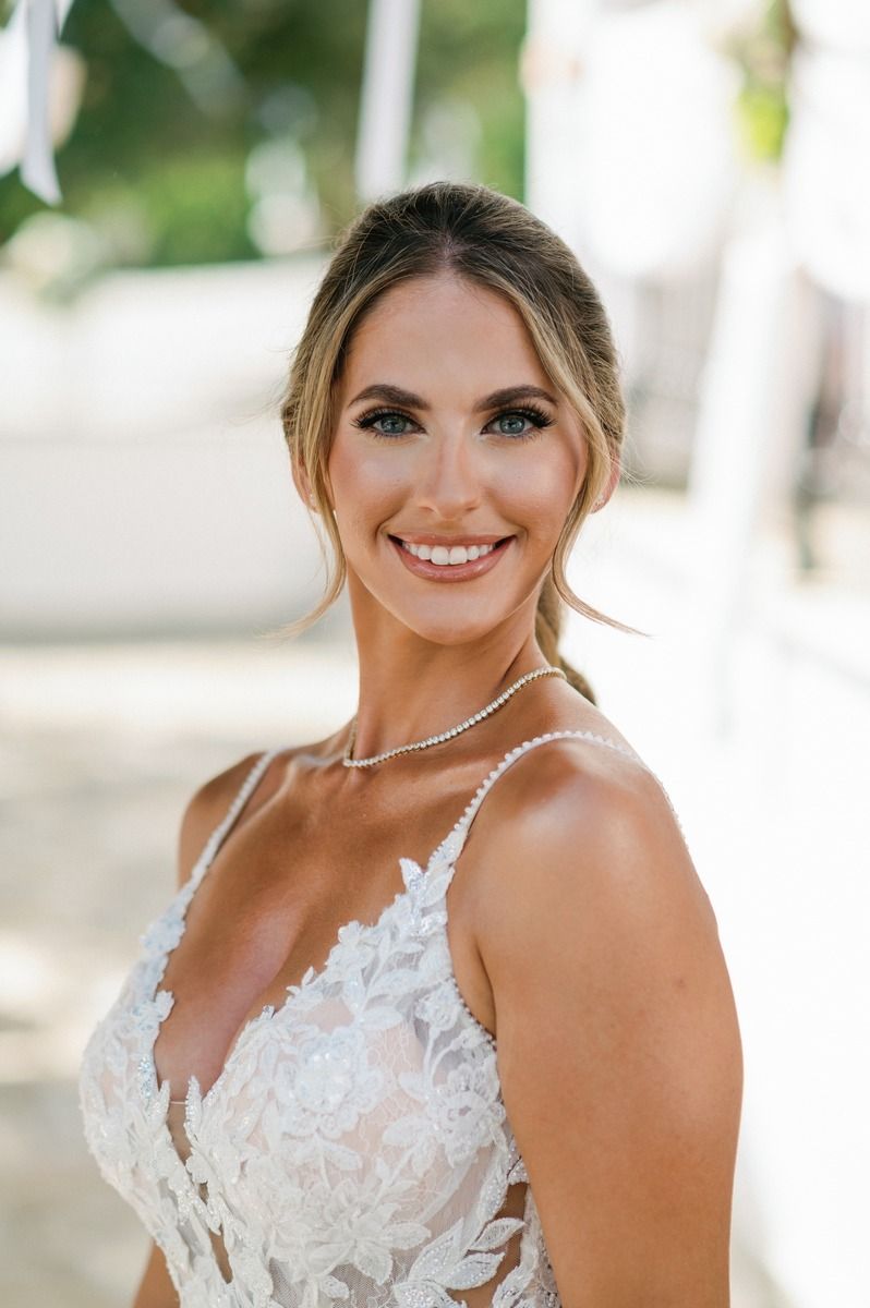 Outdoor bridal portrait featuring an intricately detailed white lace wedding dress.