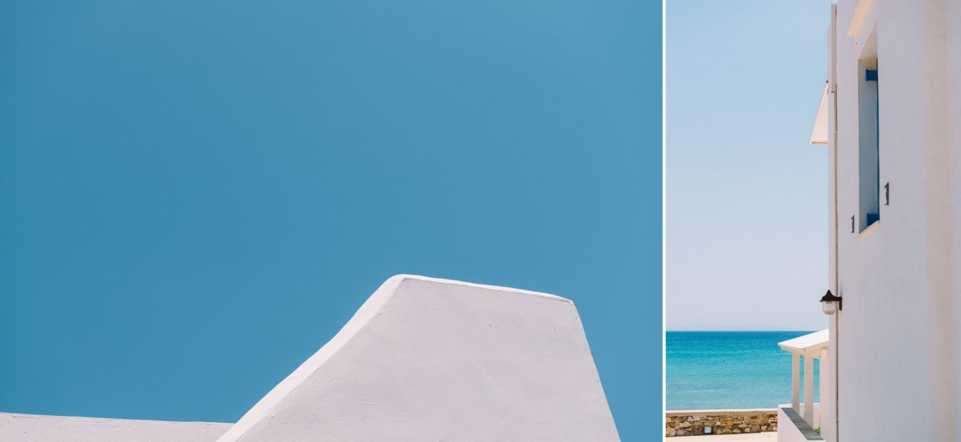 Minimalist architectural details of a white Mediterranean building against bright blue sky.
