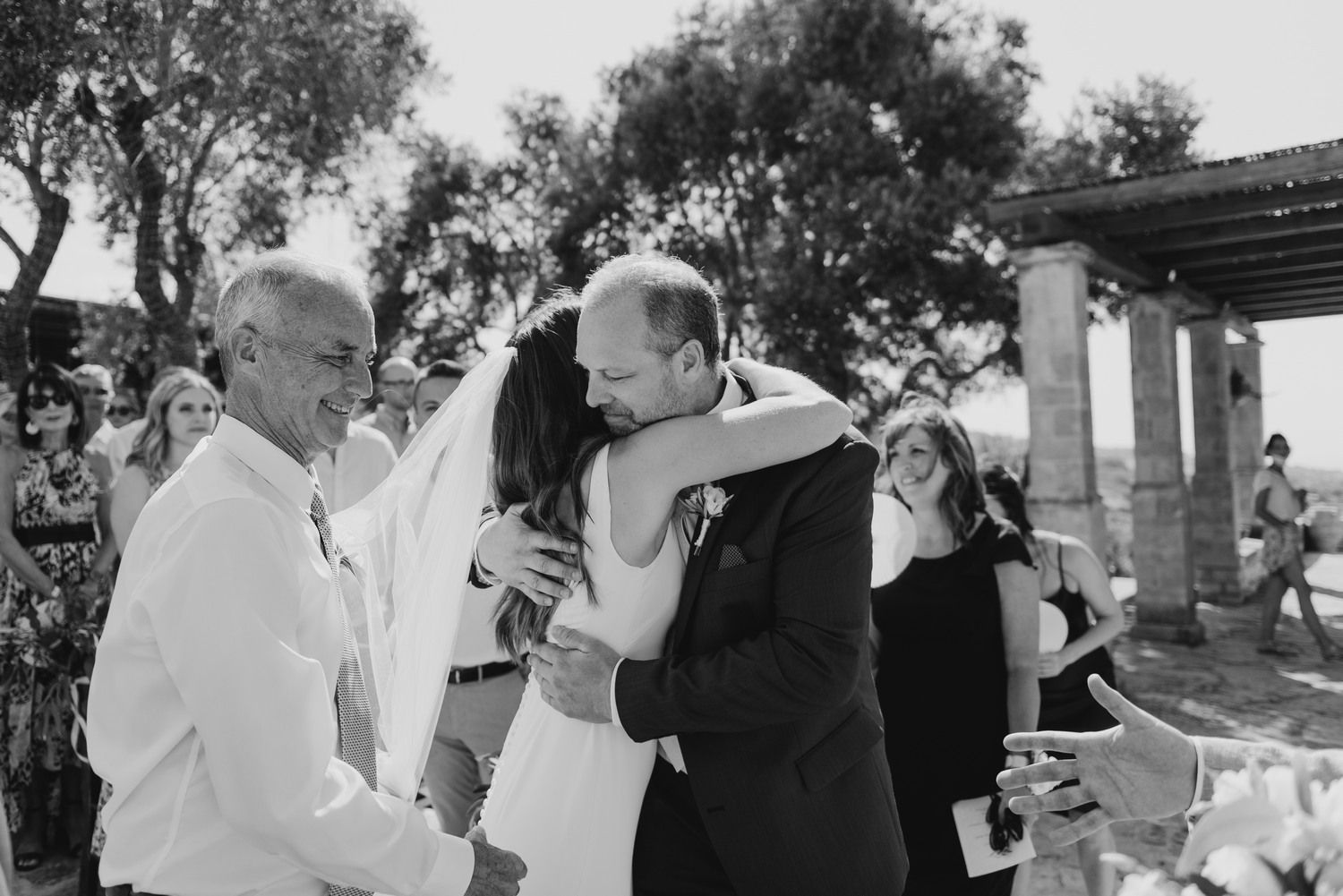 Emotional moment during a wedding celebration in an outdoor garden setting.