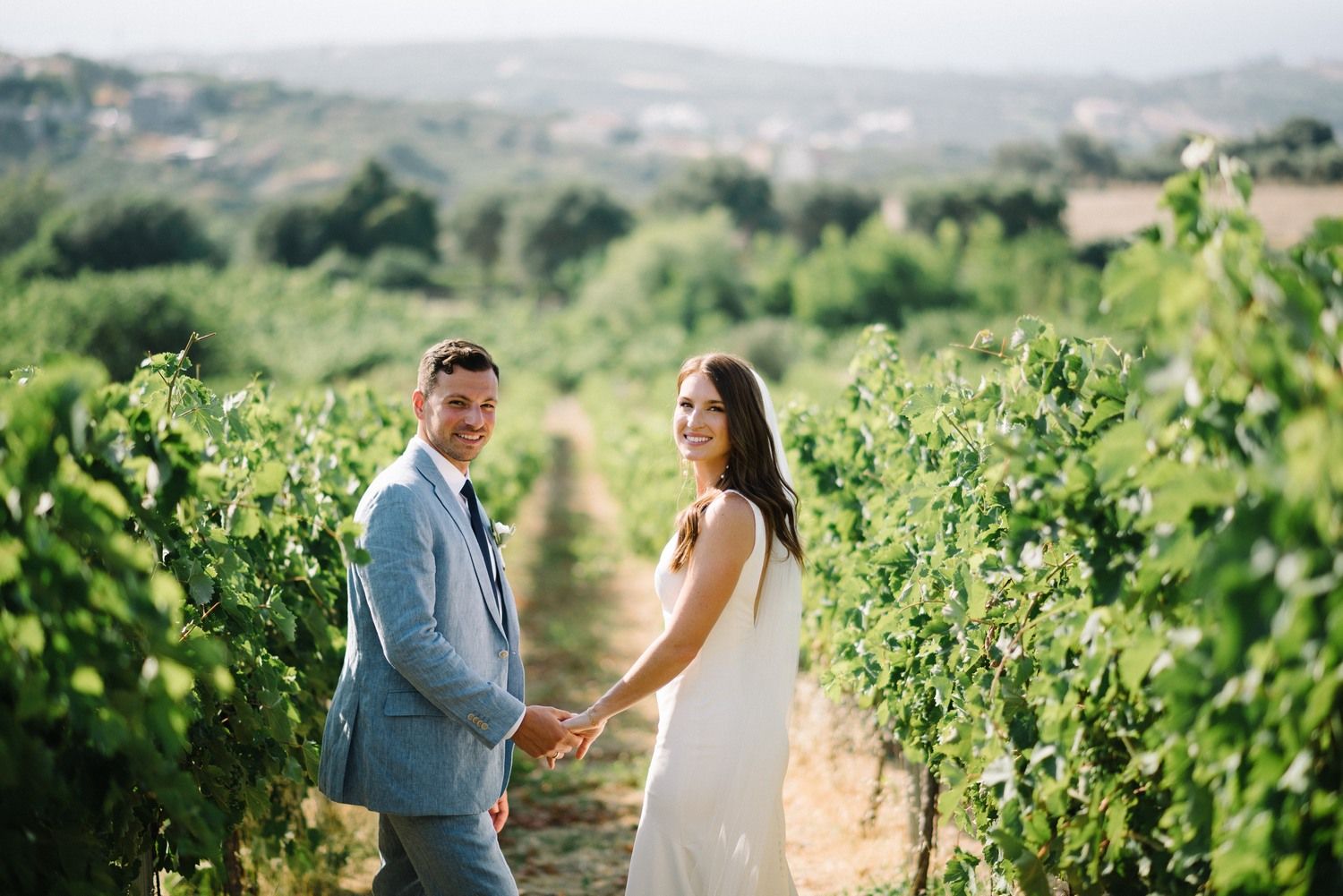 couple walking inside a vineyard at agreco farms in crete greece