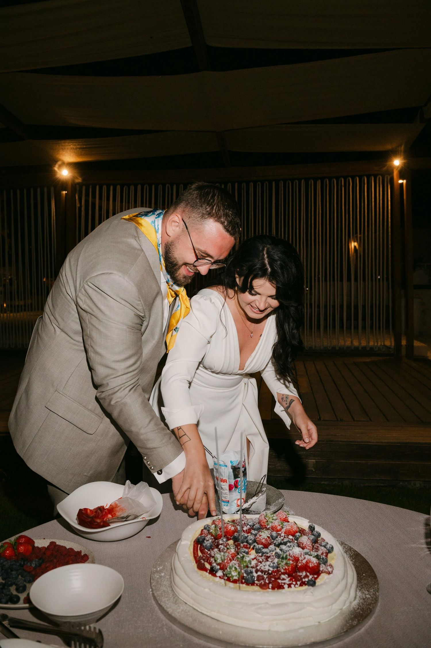 A couple cuts their wedding cake together in a sequence of photos showing them slicing and serving the decorated dessert.