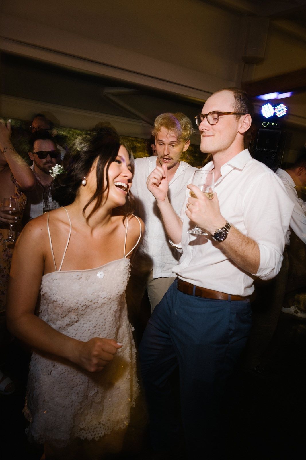 Partygoers share a fun moment dancing together at a wedding reception.