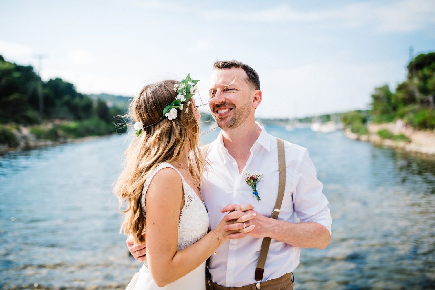 Happy couple laughs together during waterfront wedding portraits by marina.