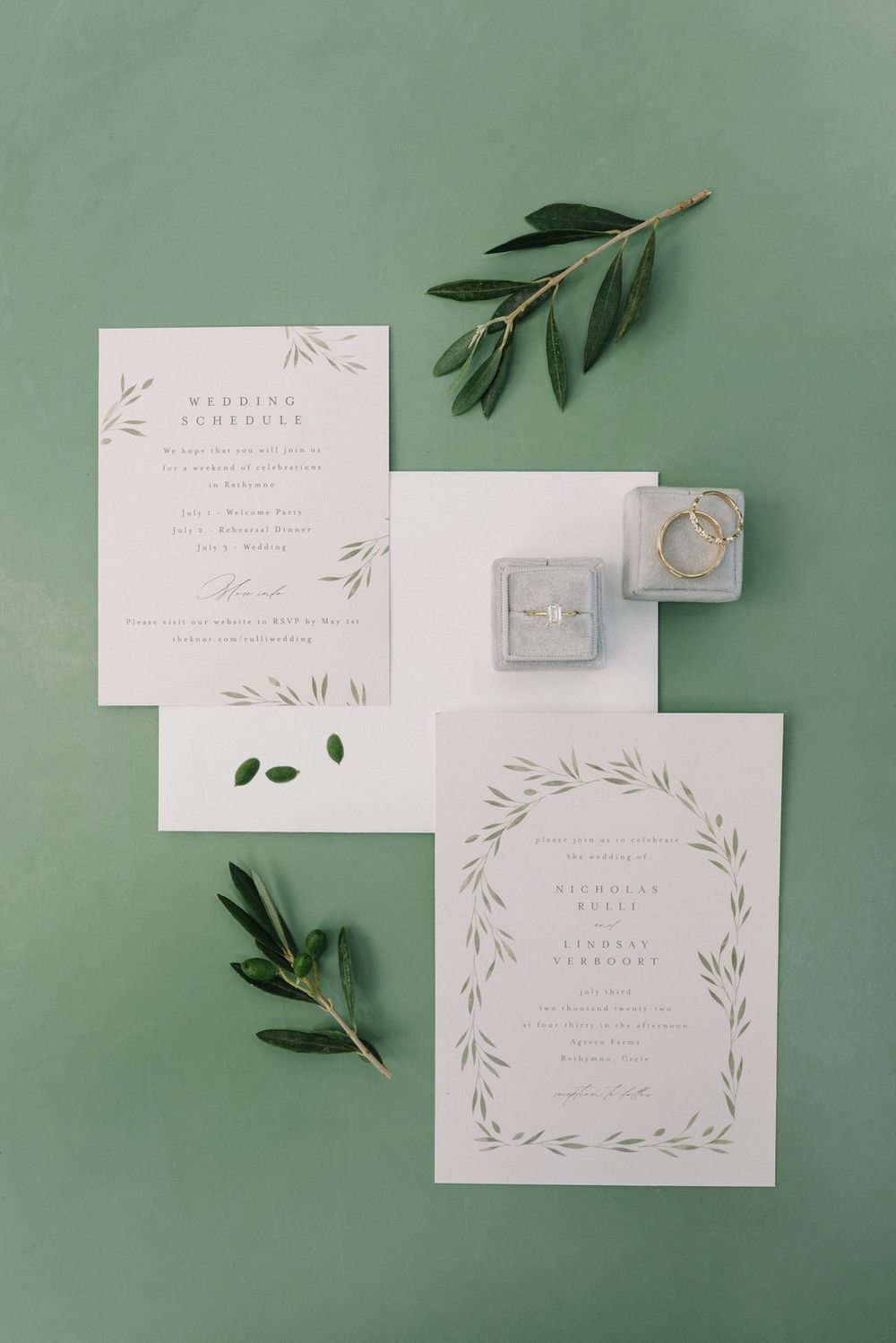 Minimalist wedding stationery suite with olive branches and leaves on sage green background.