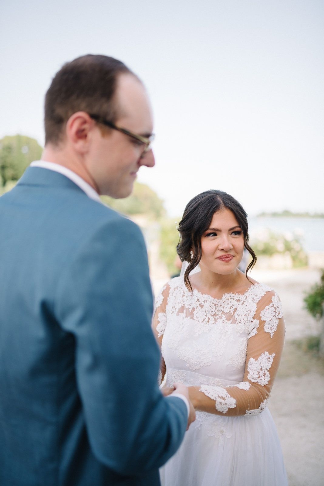 Couple exchanging vows during outdoor waterfront wedding ceremony.