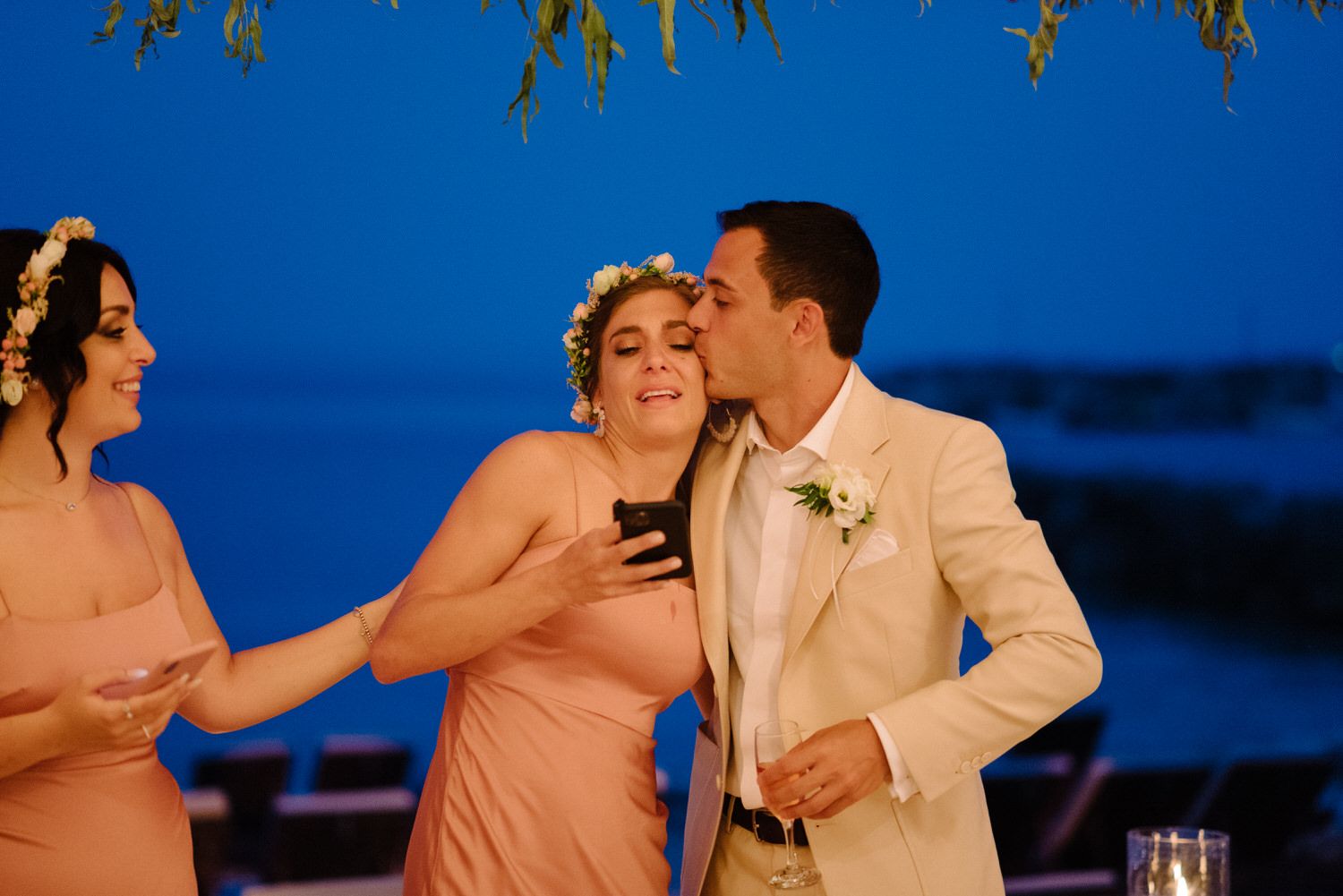 Wedding celebration moment captured against blue twilight sky with string lights overhead.