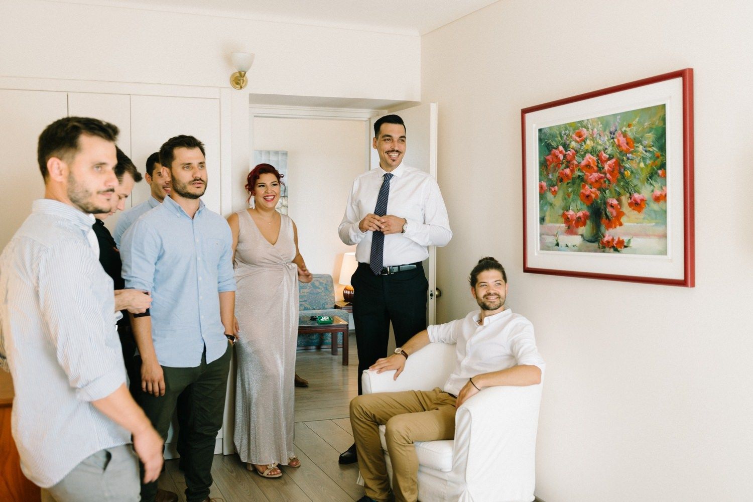 Two people sharing a cheerful moment while getting dressed for a formal occasion.