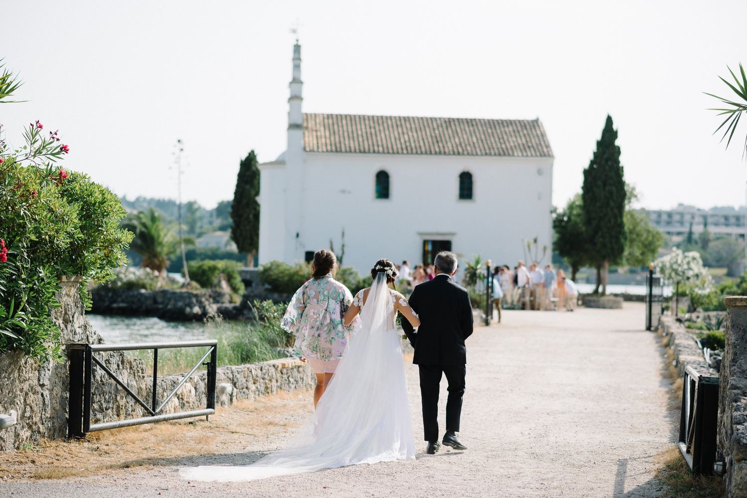 Couple walking towards a white Mediterranean church on their wedding day.