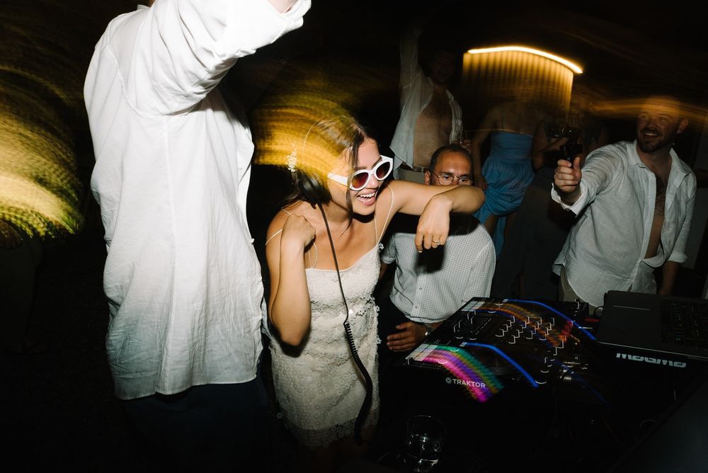 People dancing and socializing at a dimly lit nightclub or party venue.