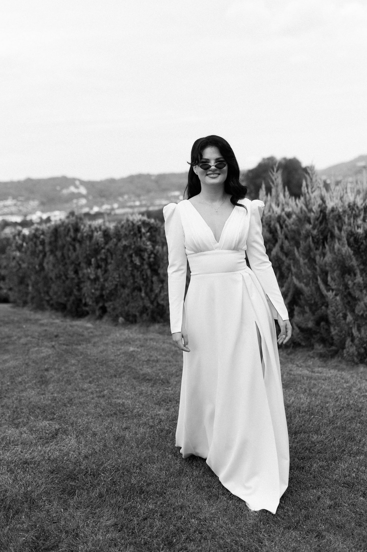 Black and white photo series showing a flowing white dress against a scenic vineyard landscape.