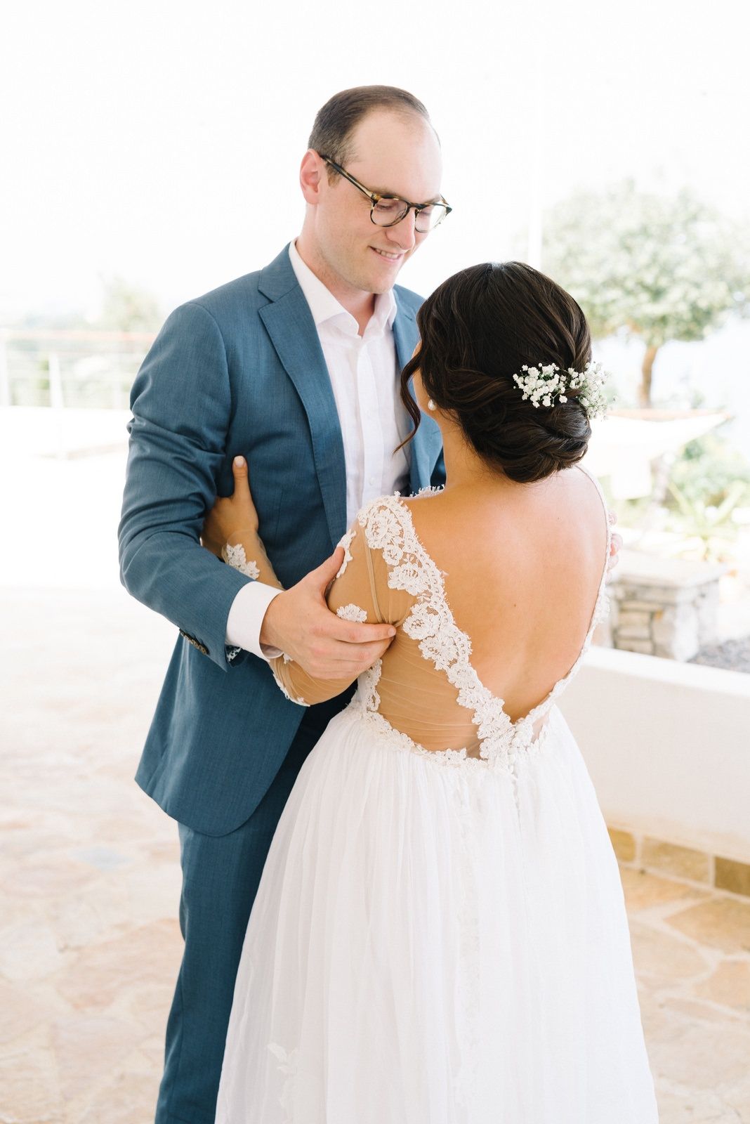 Couple shares romantic dance moment showcasing detailed lace back wedding dress.