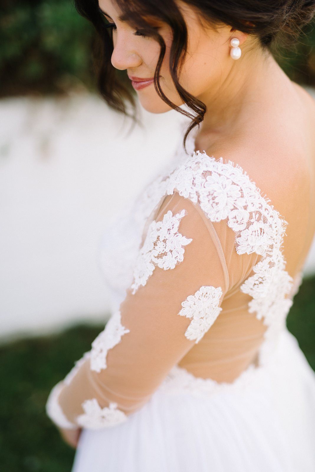Detail shot of delicate lace sleeve and shoulder of wedding gown.