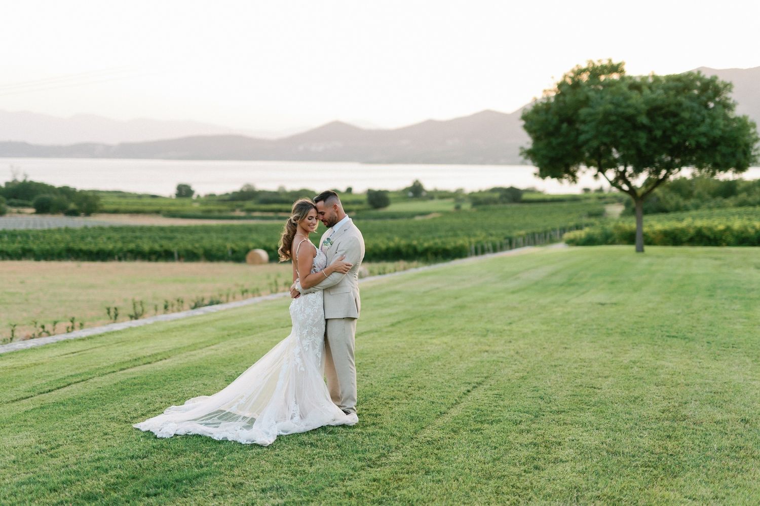 couple hugging in a vineyard with a lake in Greece