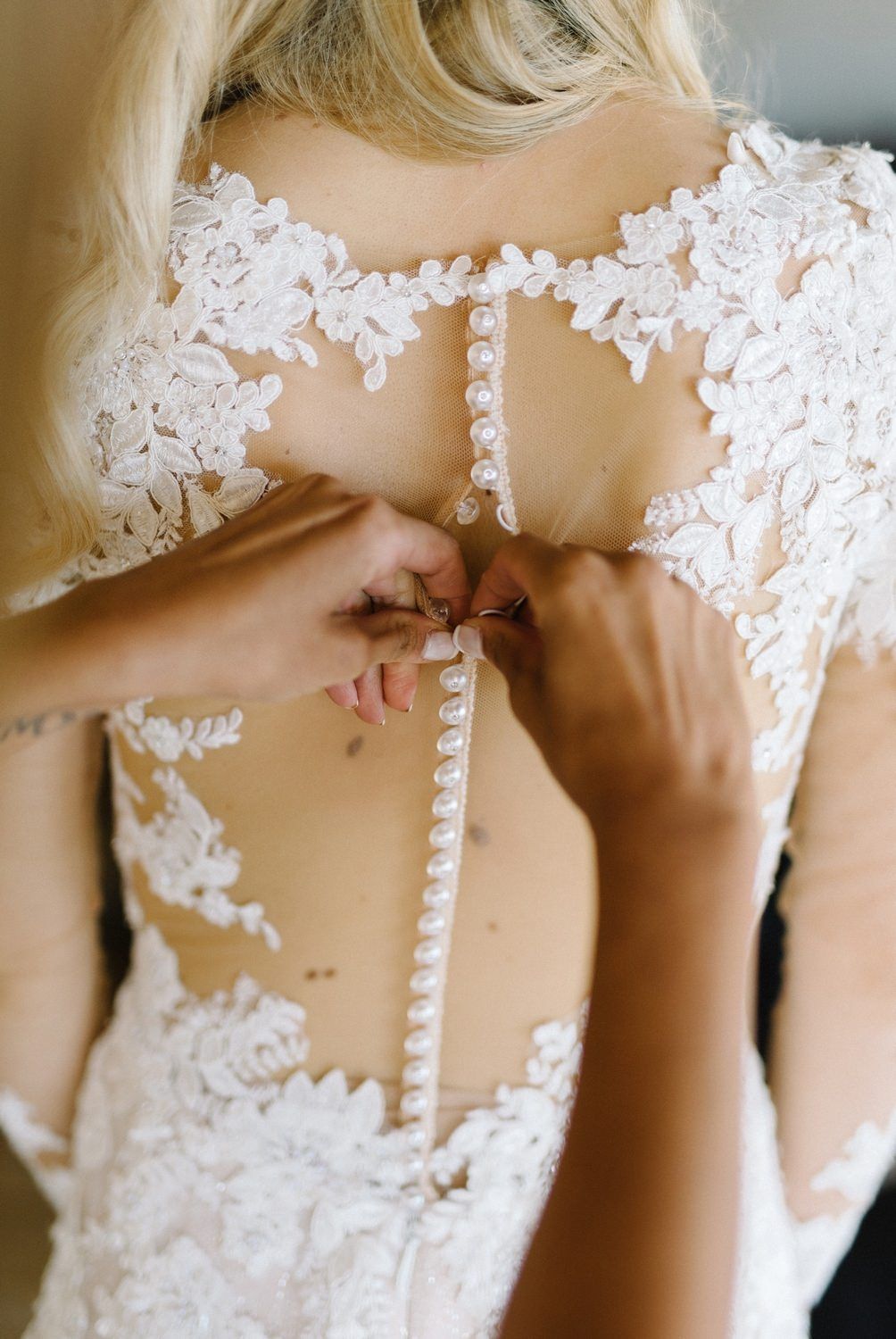 Close up detail of intricate lace buttons on back of wedding gown.