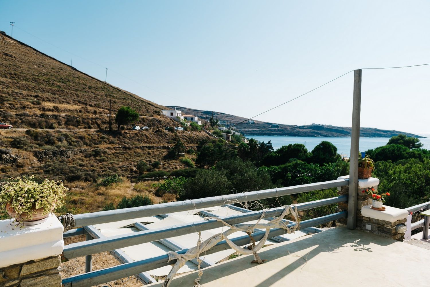 Scenic coastal view of a Mediterranean landscape with mountains and sea from a white balcony.