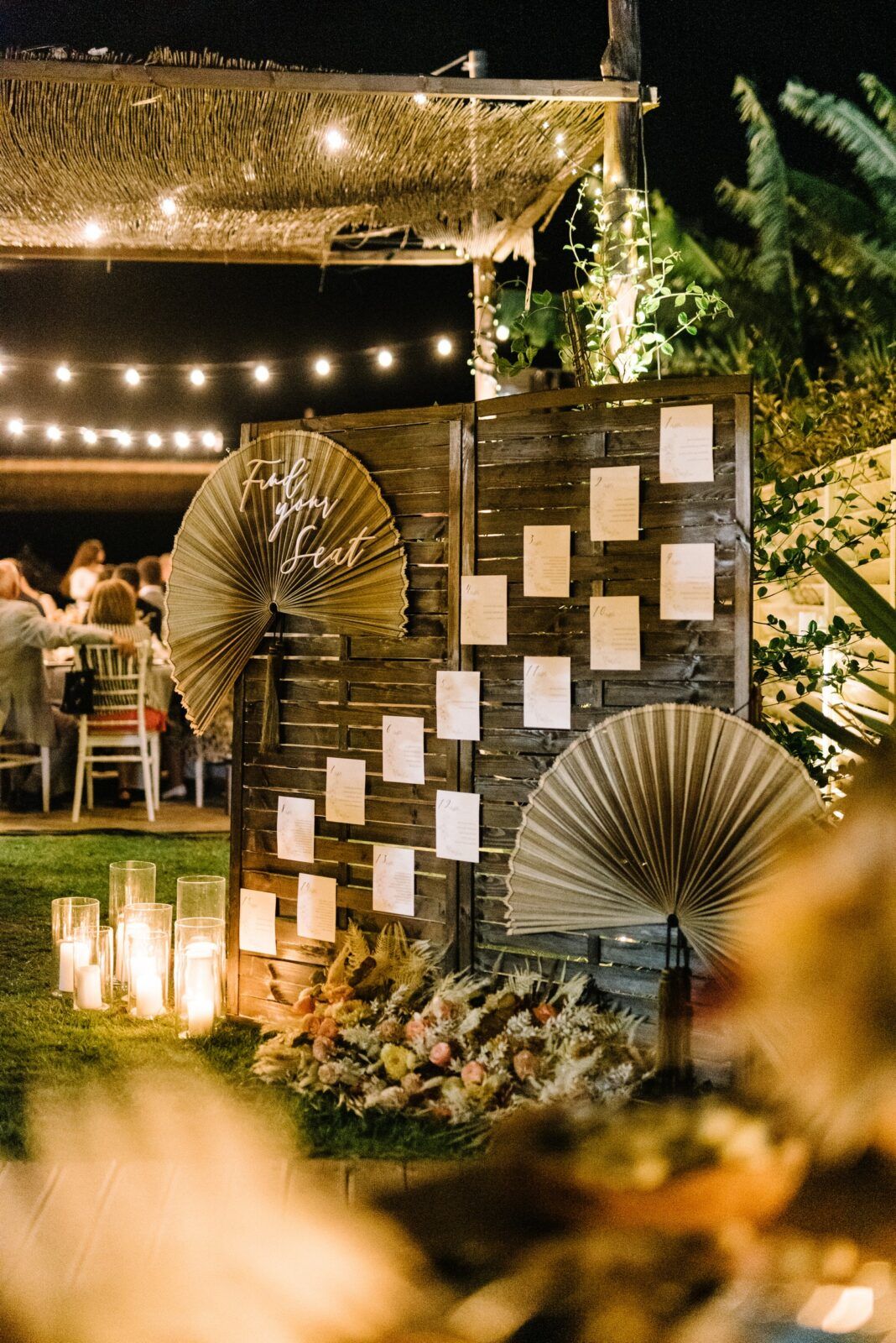 Rustic outdoor wedding decor with hanging paper lanterns and string lights creating a warm evening ambiance at Mango beach bar, Preveza