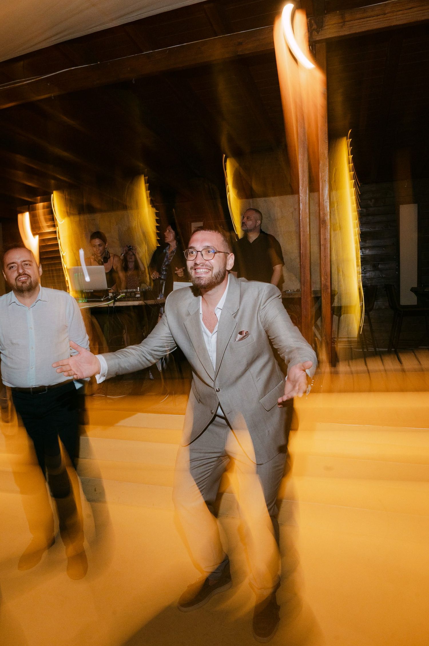 A series of motion blur photos showing a person in a gray suit dancing in a dimly lit space.