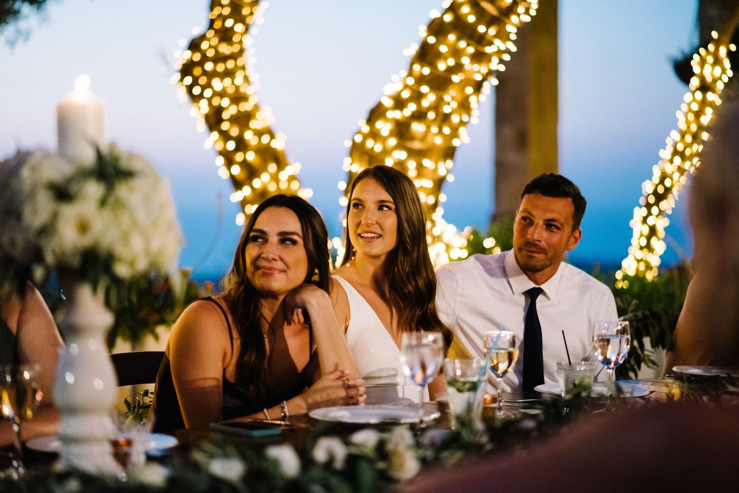 Wedding reception dinner scene with string lights and glowing decorations creating a magical atmosphere.