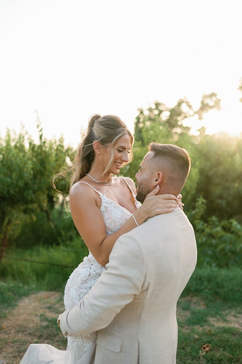 Couple embraces during sunset portrait session in garden setting.