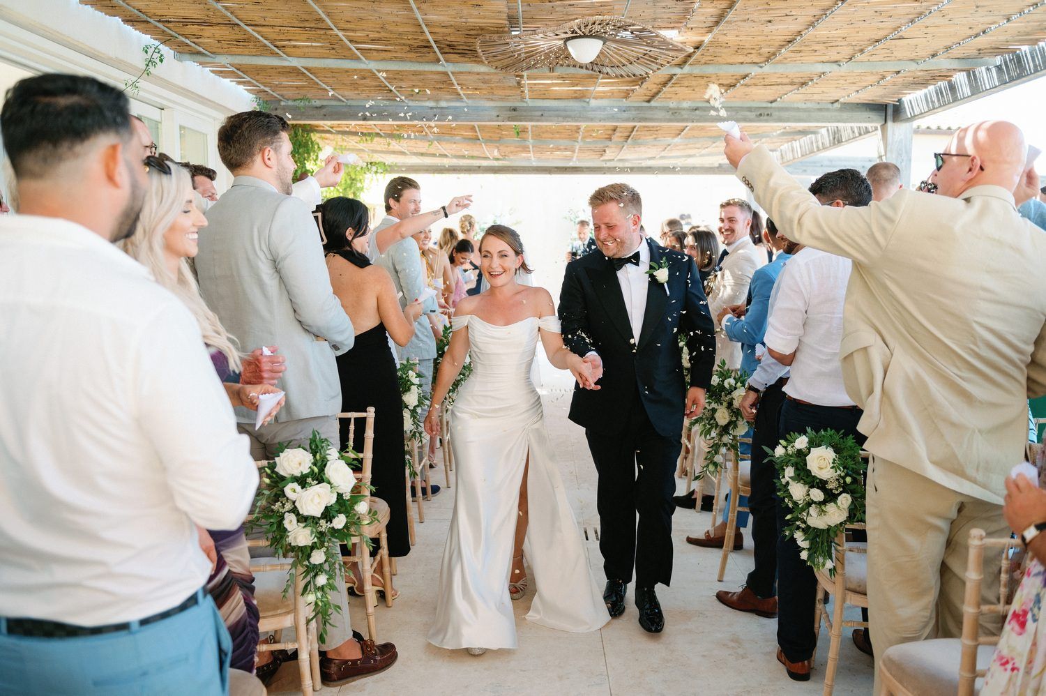 Wedding recessional with guests lining the aisle and celebrating the newlyweds.