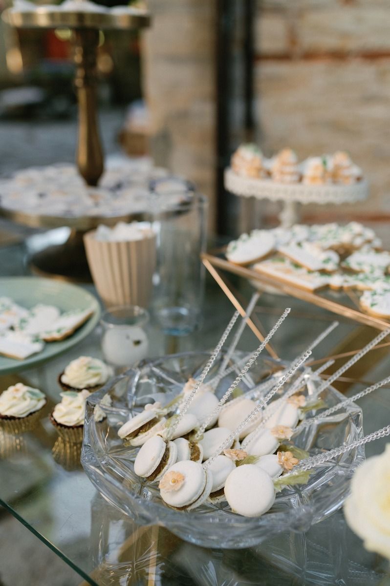 Elegant dessert display featuring cake pops and cupcakes on tiered stands at an upscale event.