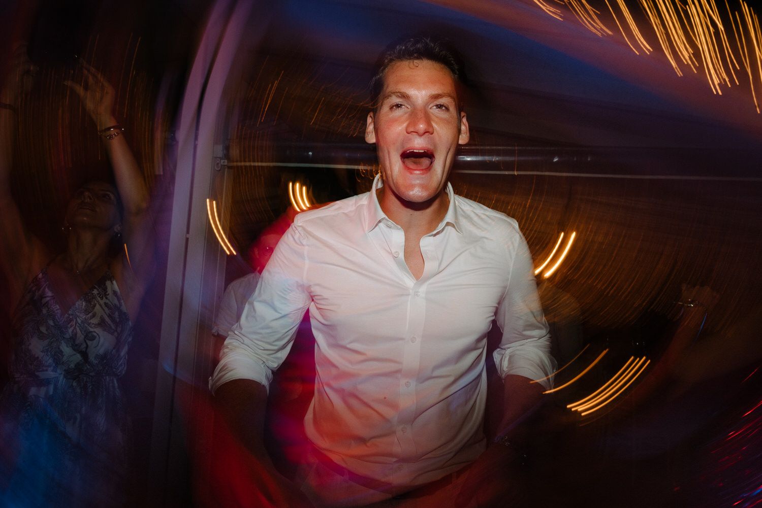 Candid party moment captured with dramatic nightclub lighting effects.