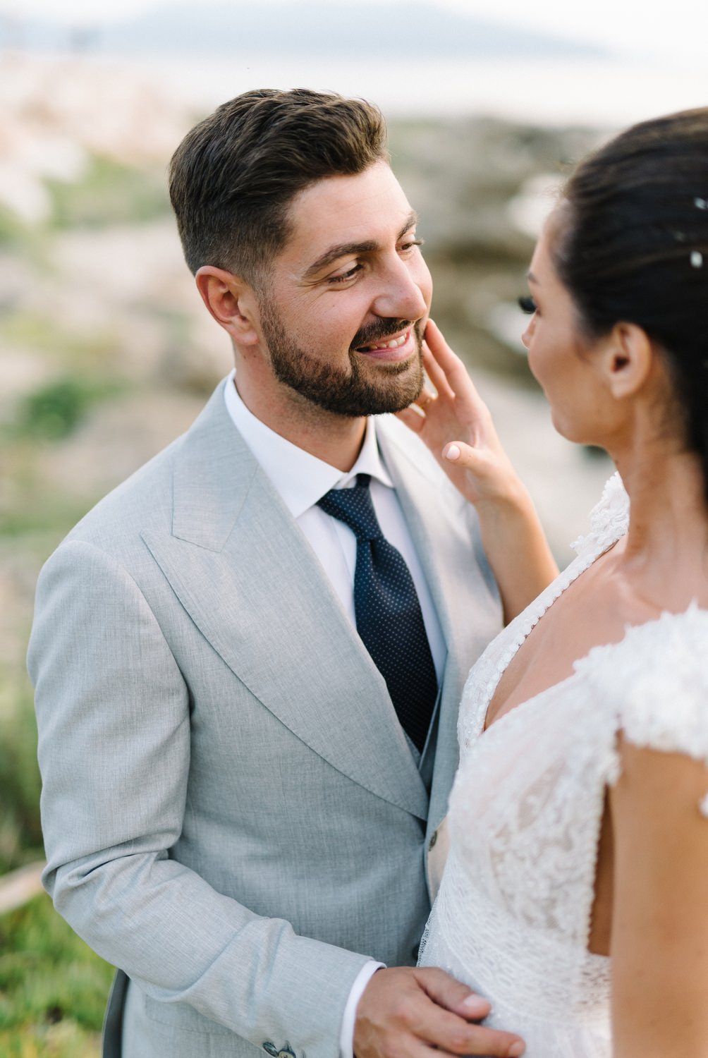Intimate wedding portrait showing tender moment between newlyweds in elegant attire.