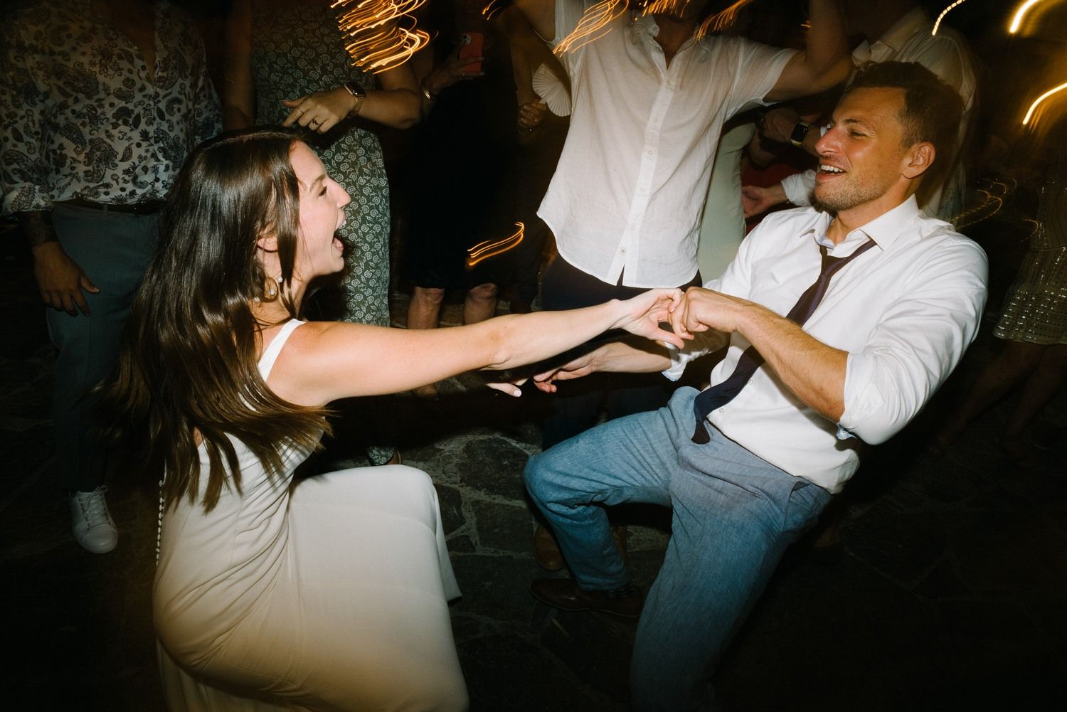 Energetic dancers share a joyful moment on the dance floor during a nighttime celebration.