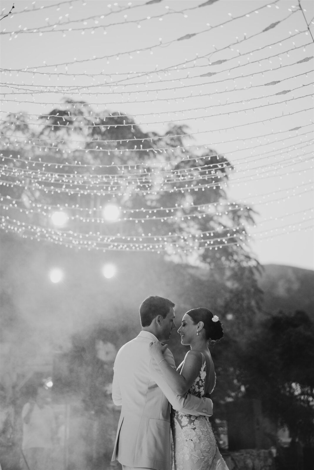 Evening wedding reception under twinkling string lights creating a romantic atmosphere.