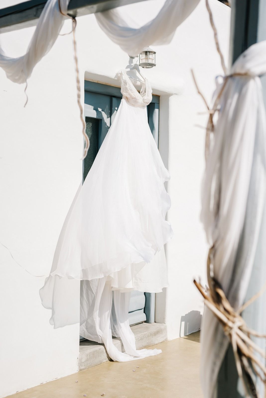 Elegant white wedding dress hanging on display with natural lighting.