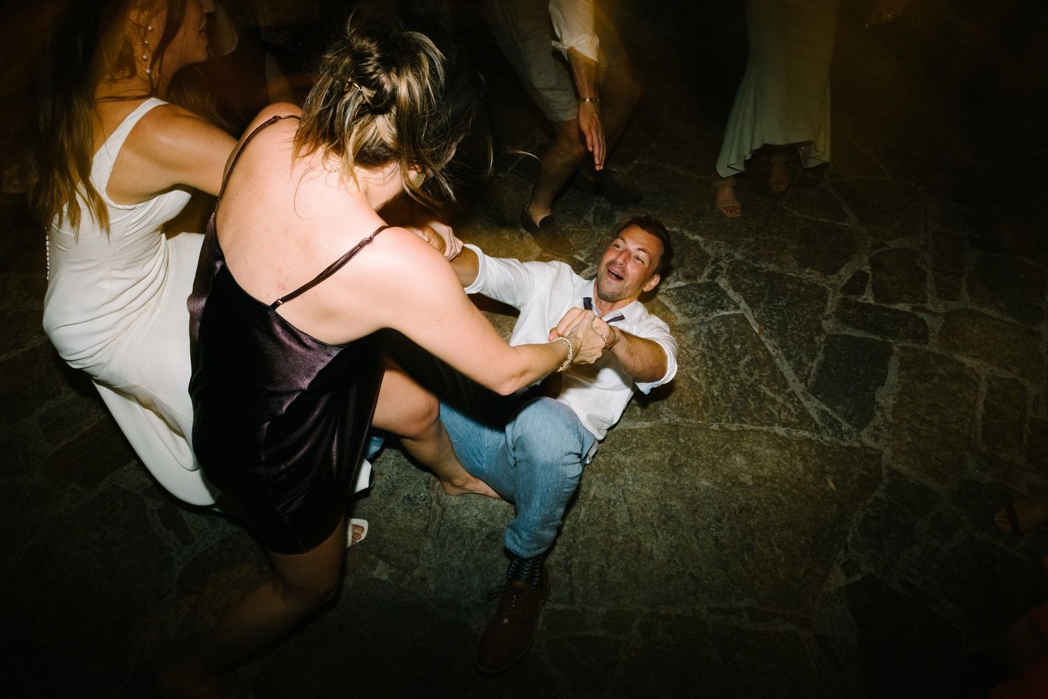 Dynamic dance moves captured during an energetic party celebration on stone flooring.